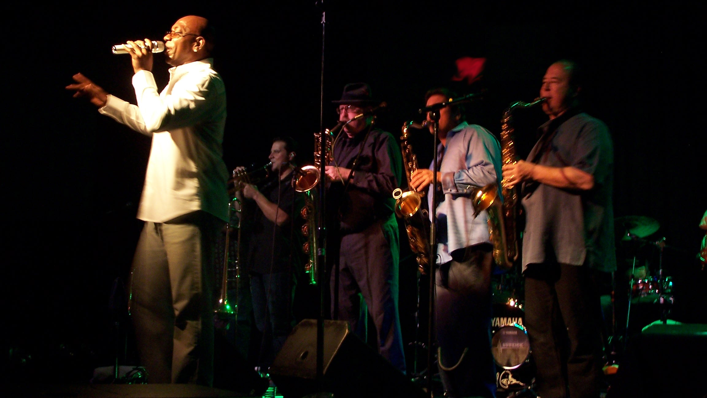 four guys on saxes and horns backing a vocalist