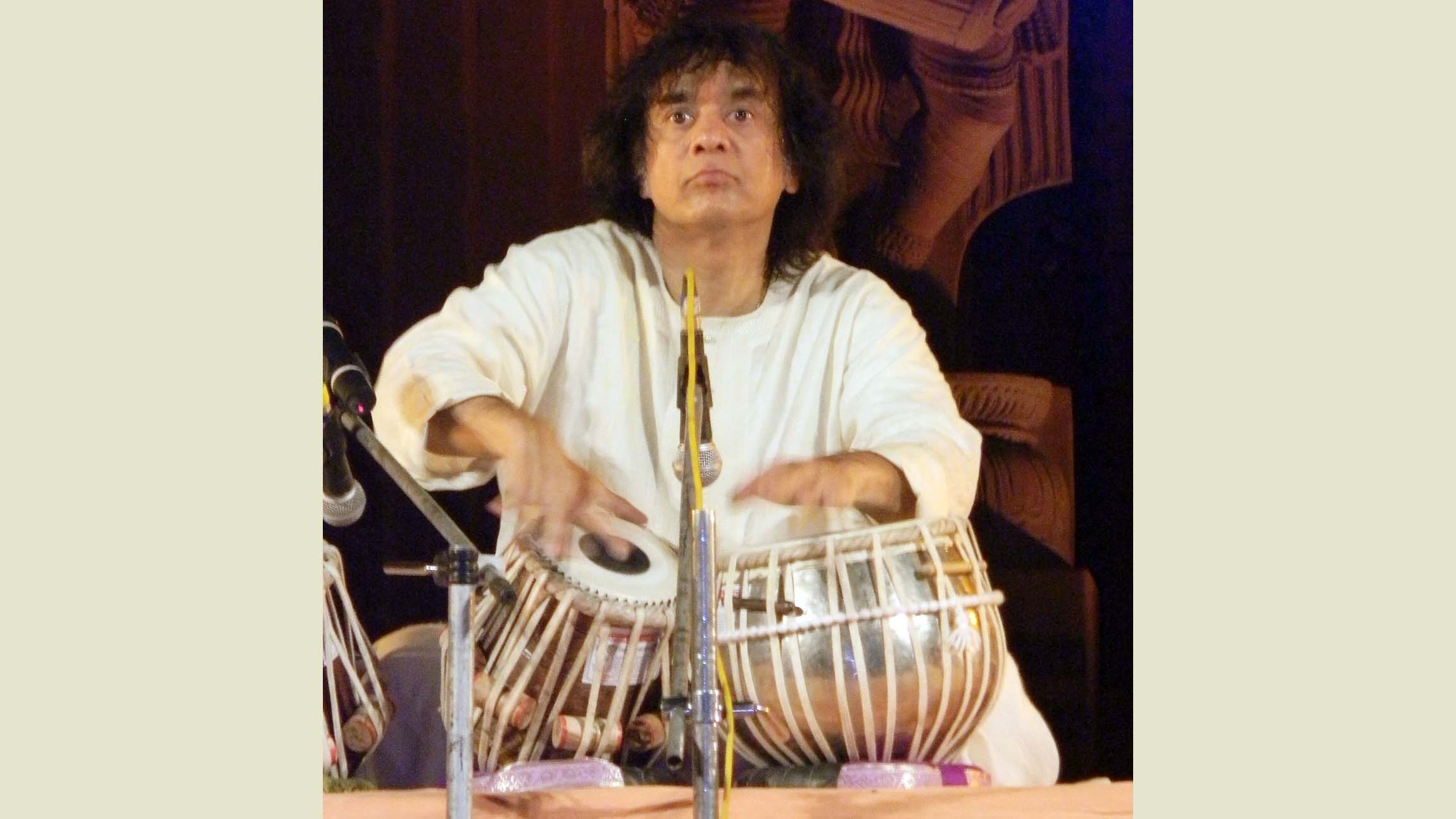 man playing drums in a white robe